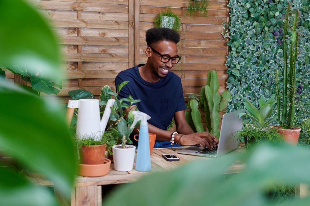 Smiling Young Man Using Laptop On His Terrace XSCC5V7