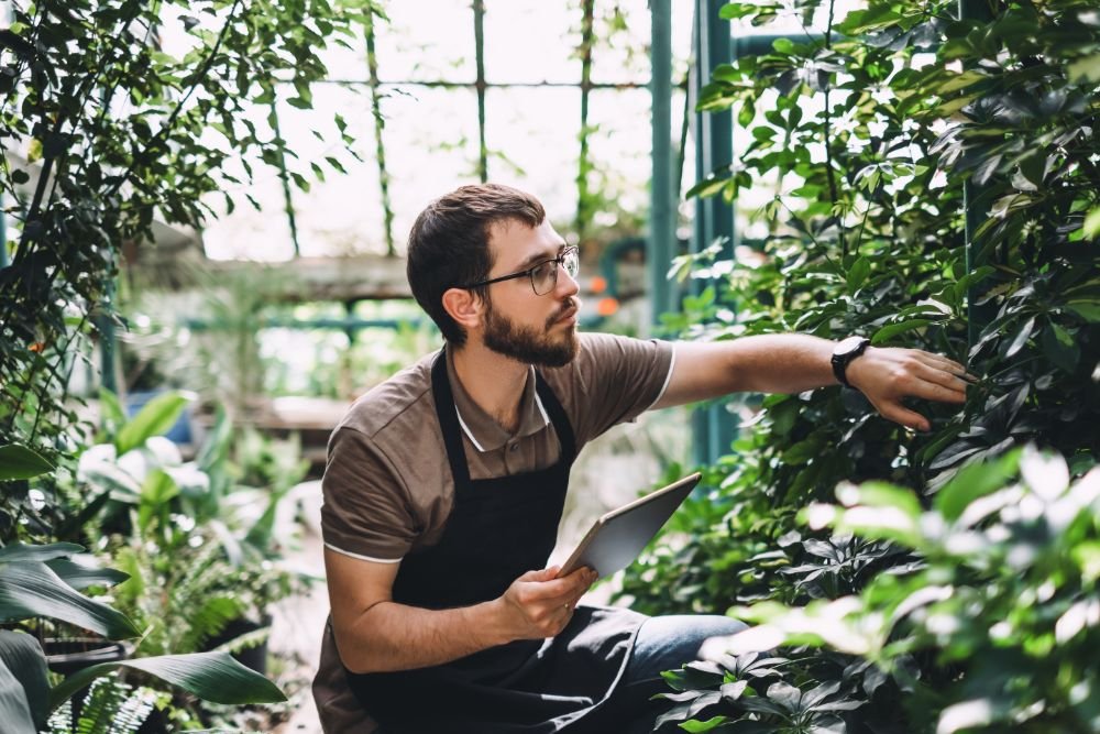 Young Man Gardener In Glasses And Apron With Digit U9LPEAD